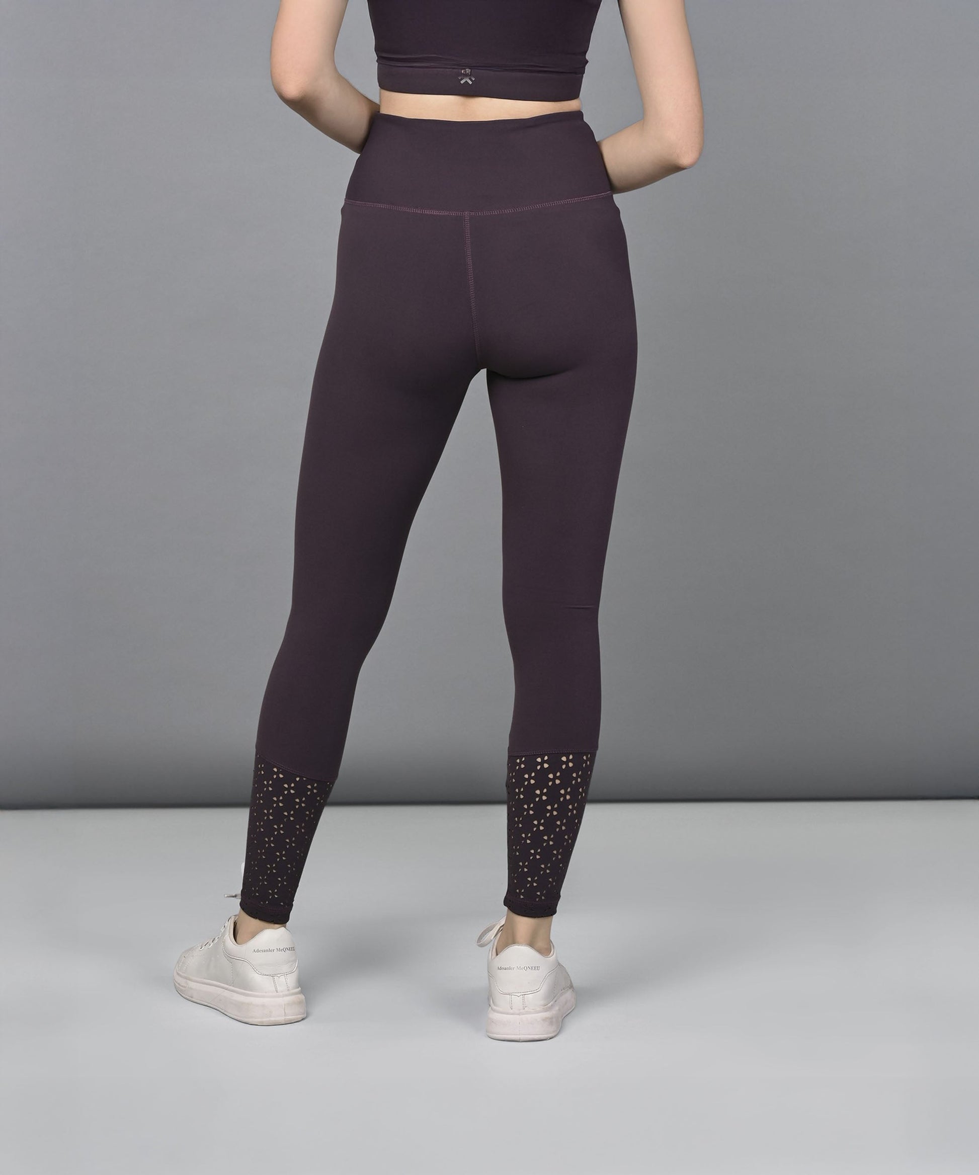 Trendy women's leggings in dark purple with stylish mesh detailing at the ankles