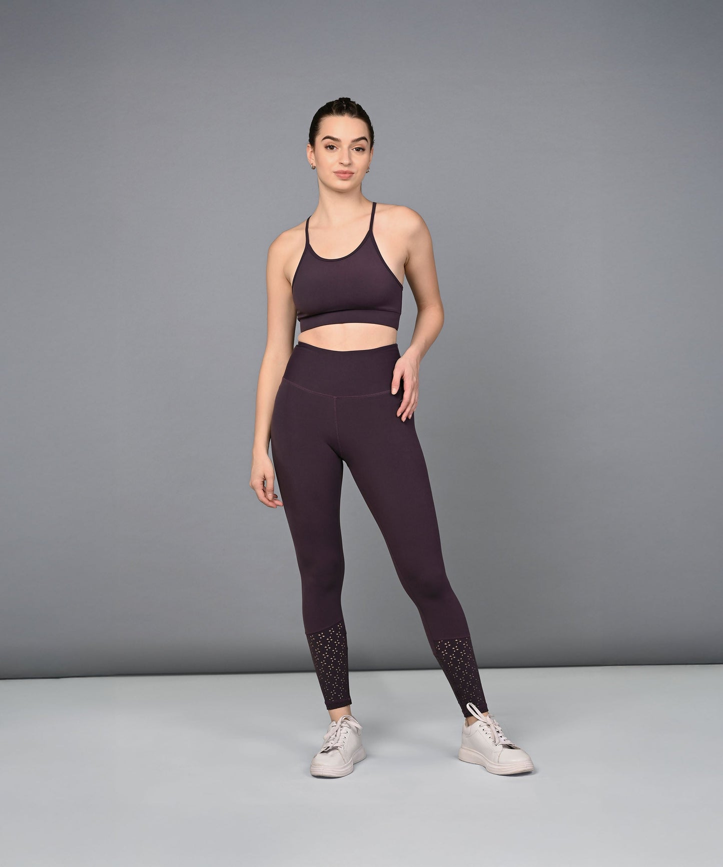 Trendy women's leggings in dark purple paired with a matching sports bra for activewear enthusiasts