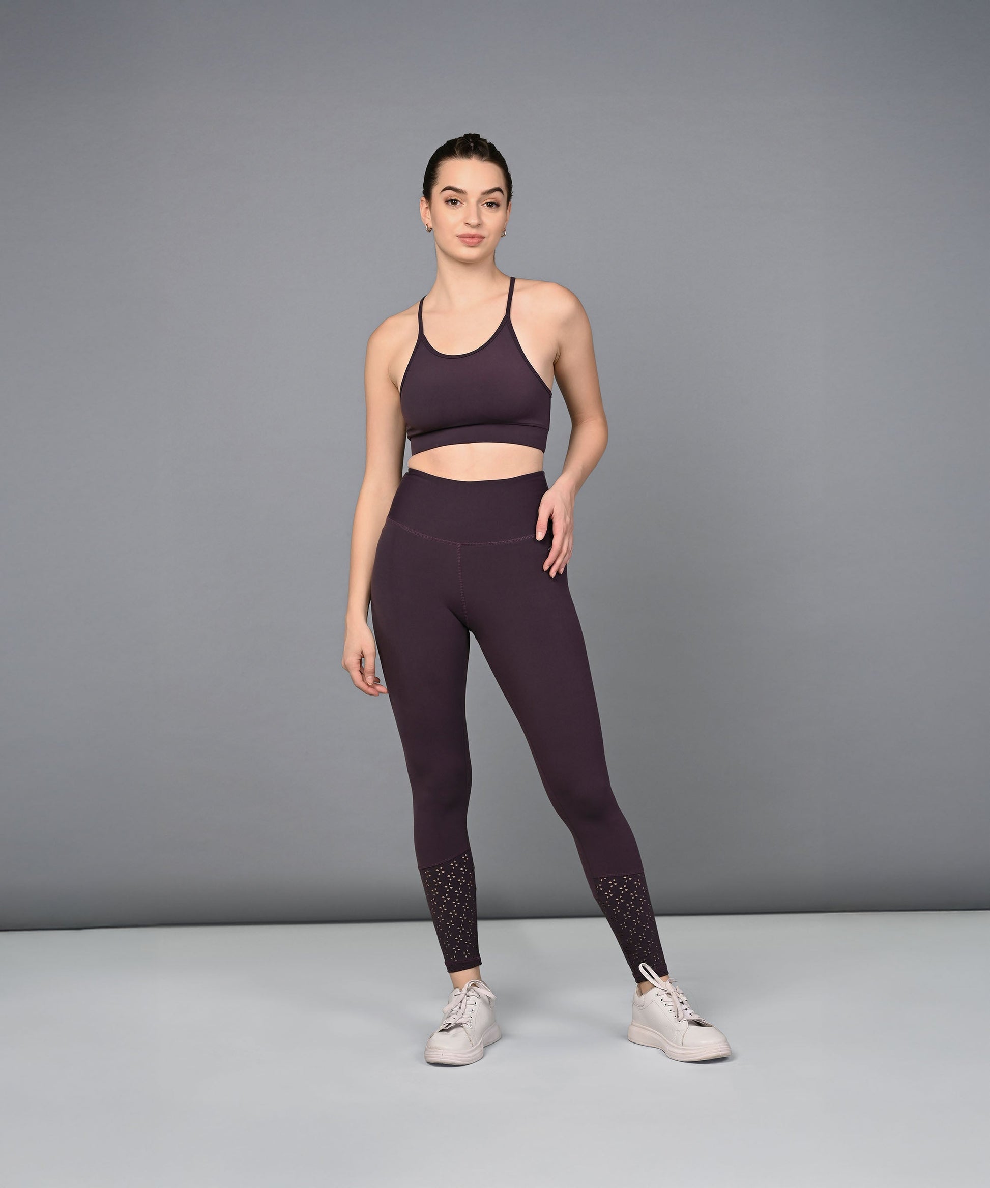 Trendy women's leggings in dark purple paired with a matching sports bra for activewear enthusiasts