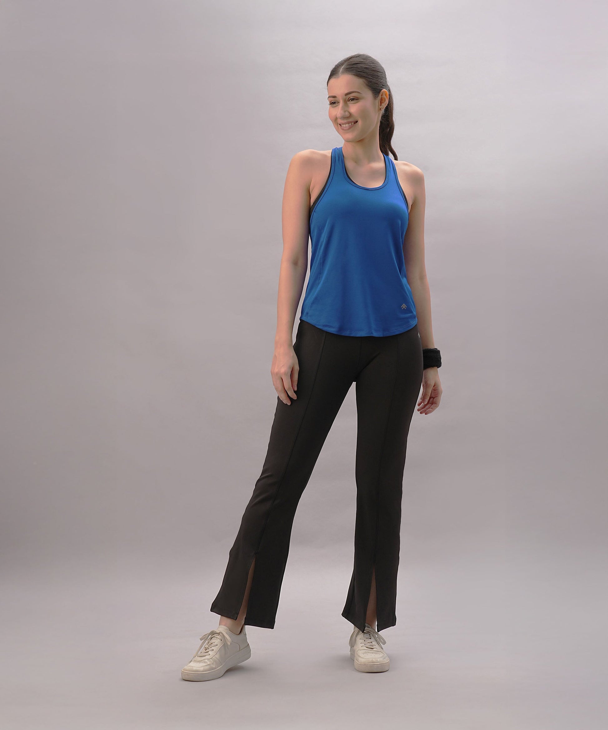 Blue Stylera trendy workout tank top for women paired with black workout pants and sneakers