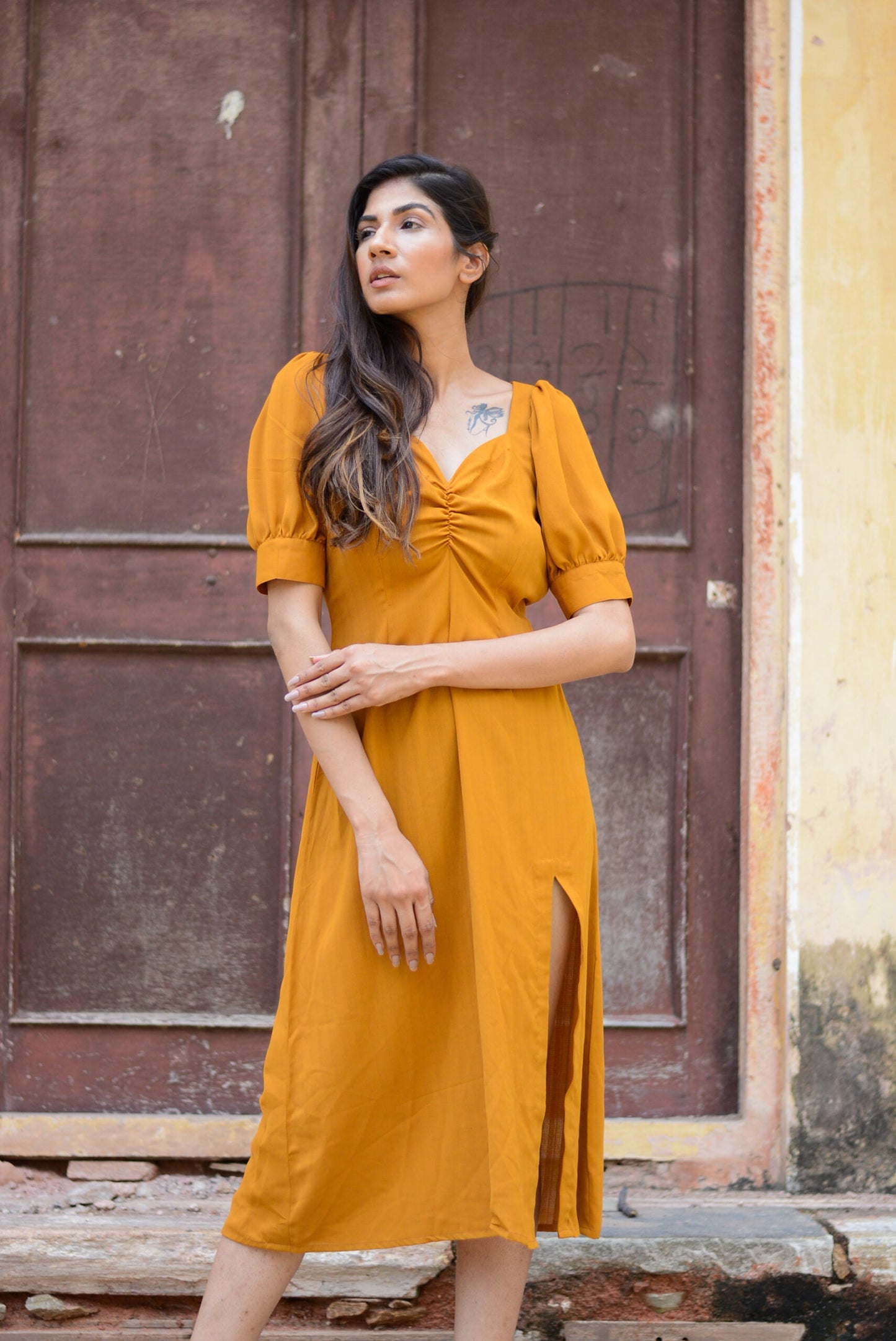 Trendy yellow slit midi dress with a flattering fit and puff sleeves, perfect for stylish summer outings