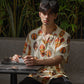 Tribal print yellow oversize shirt featuring vibrant patterns worn by a model in a relaxed setting
