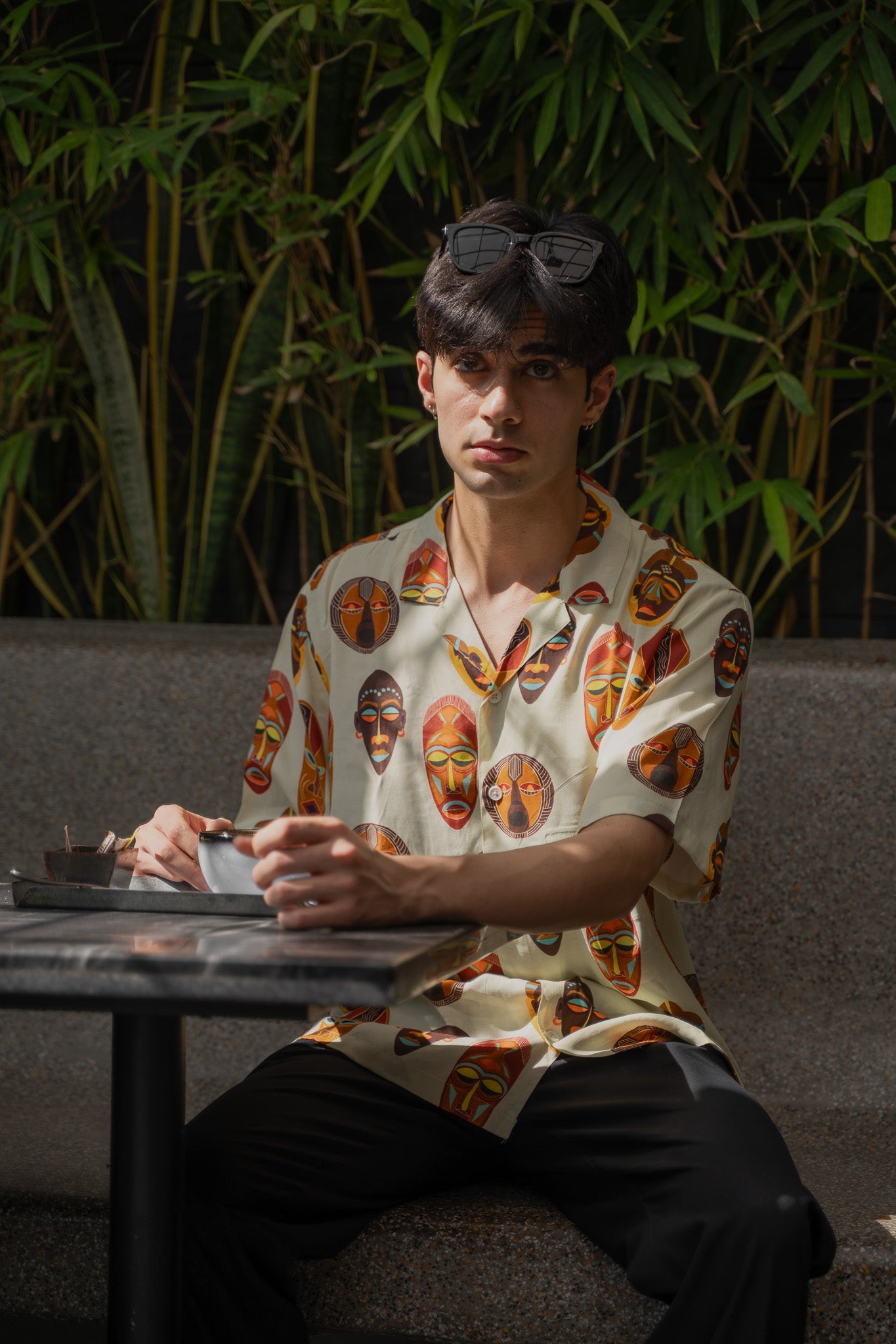 Tribal print yellow oversize shirt featuring vibrant patterns worn by a model in a relaxed setting
