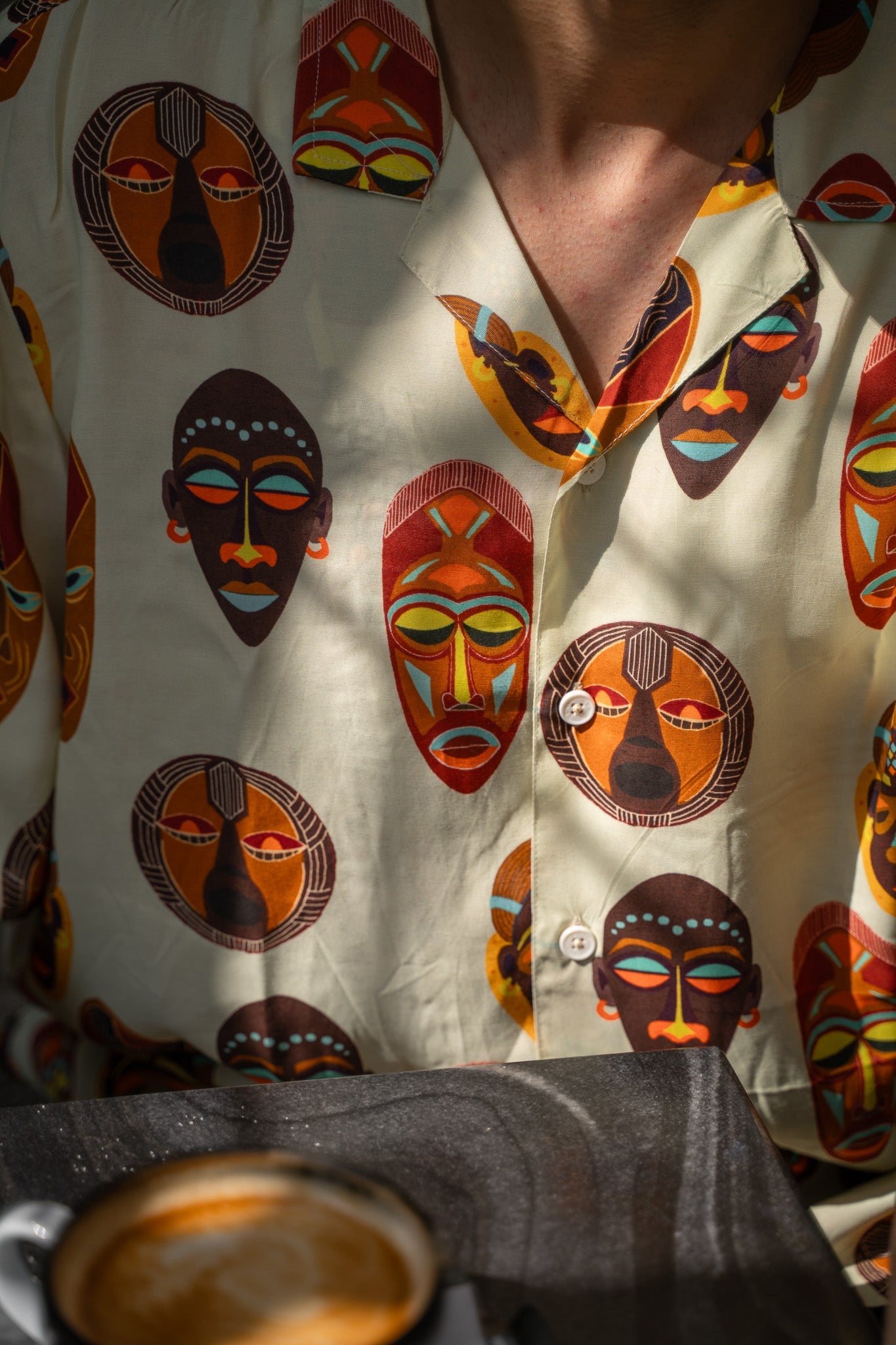 Tribal print yellow oversize shirt featuring unique face designs and vibrant colors for a bold style