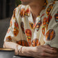 Tribal print yellow oversize shirt featuring colorful mask designs, perfect for a casual summer look.