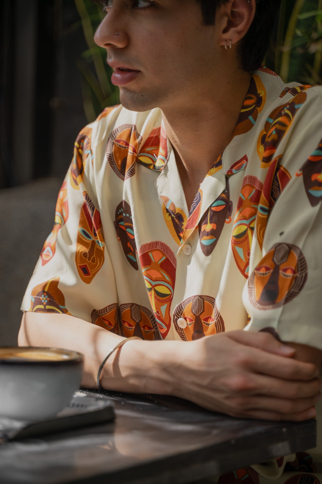Tribal print yellow oversize shirt featuring colorful mask designs, perfect for a casual summer look.