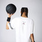 Person with braids, facing away, holding a black volleyball. Wearing the Oversize Fly Tee with a butterfly print and black wristbands.