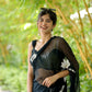 Elegant model wearing a unique black saree for party wear with floral design and stylish accessories