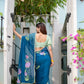 Elegant woman wearing a unique blue saree for special occasions with floral designs and a stylish blouse