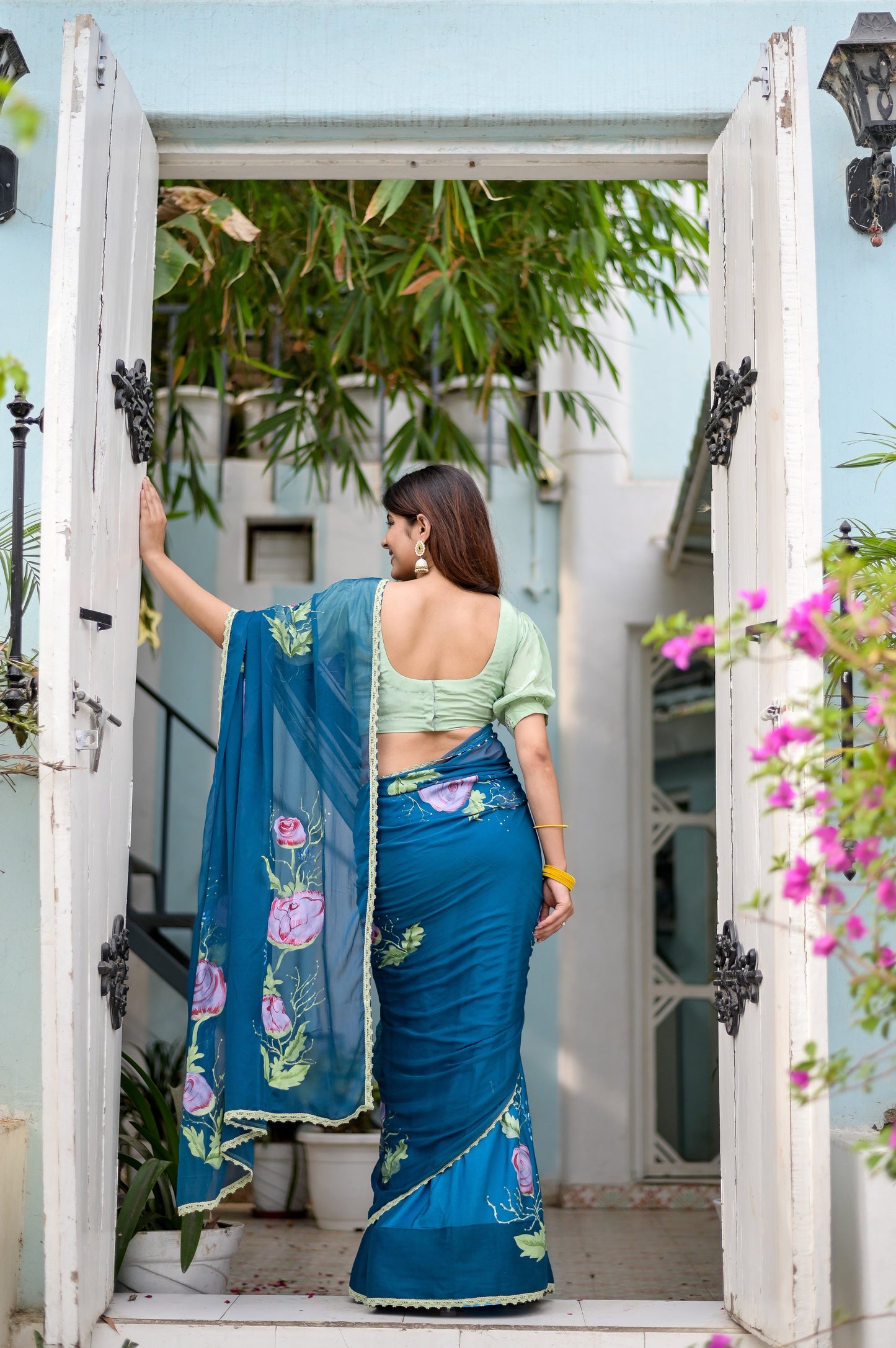 Elegant woman wearing a unique blue saree for special occasions with floral designs and a stylish blouse