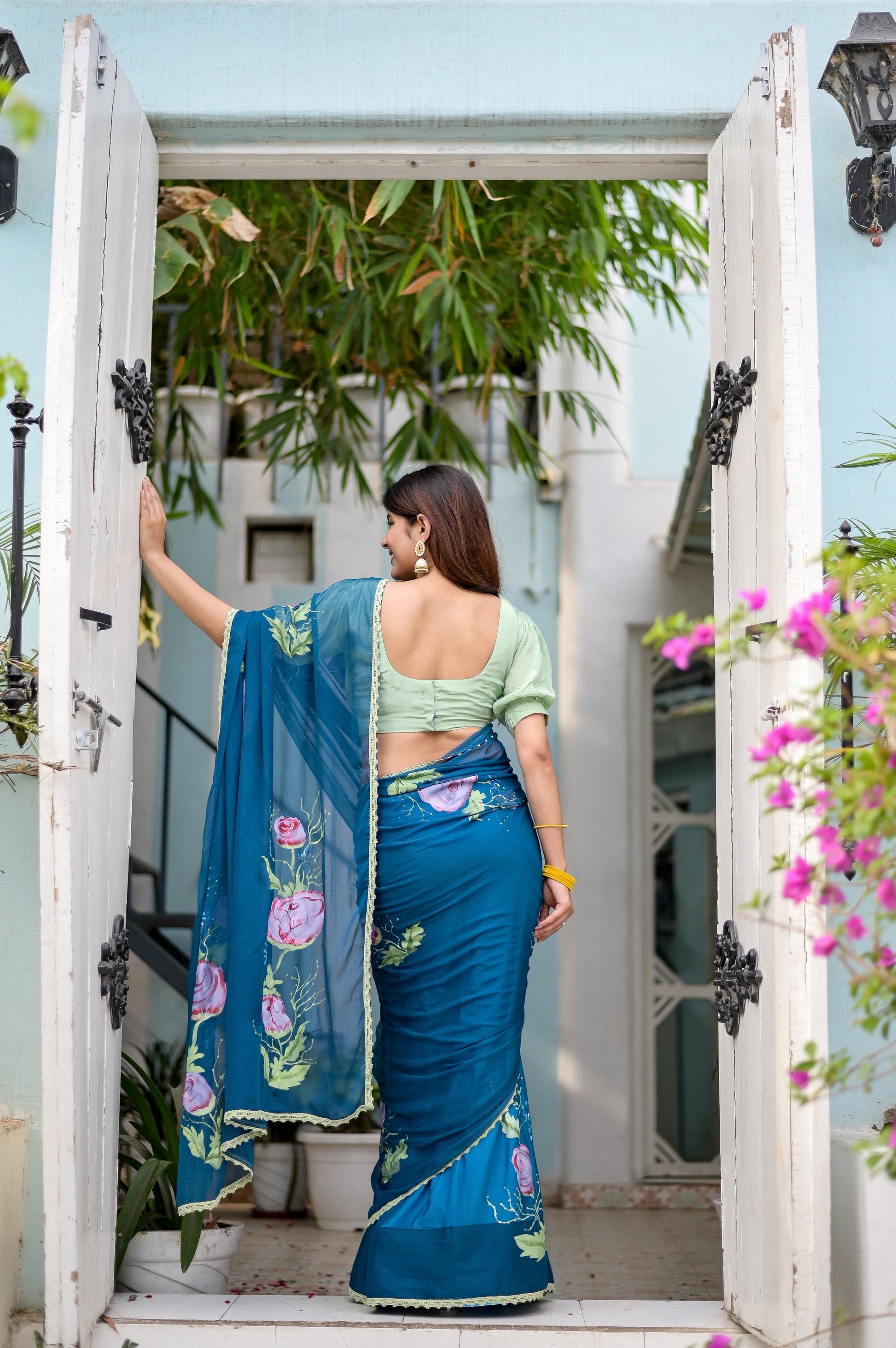 Elegant woman wearing a unique blue saree for special occasions with floral designs and a stylish blouse