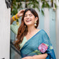 Elegant woman wearing a unique blue saree for special occasions, adorned with floral patterns and smiling