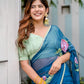 Elegant woman wearing a unique blue saree for special occasions, paired with green blouse and accessories