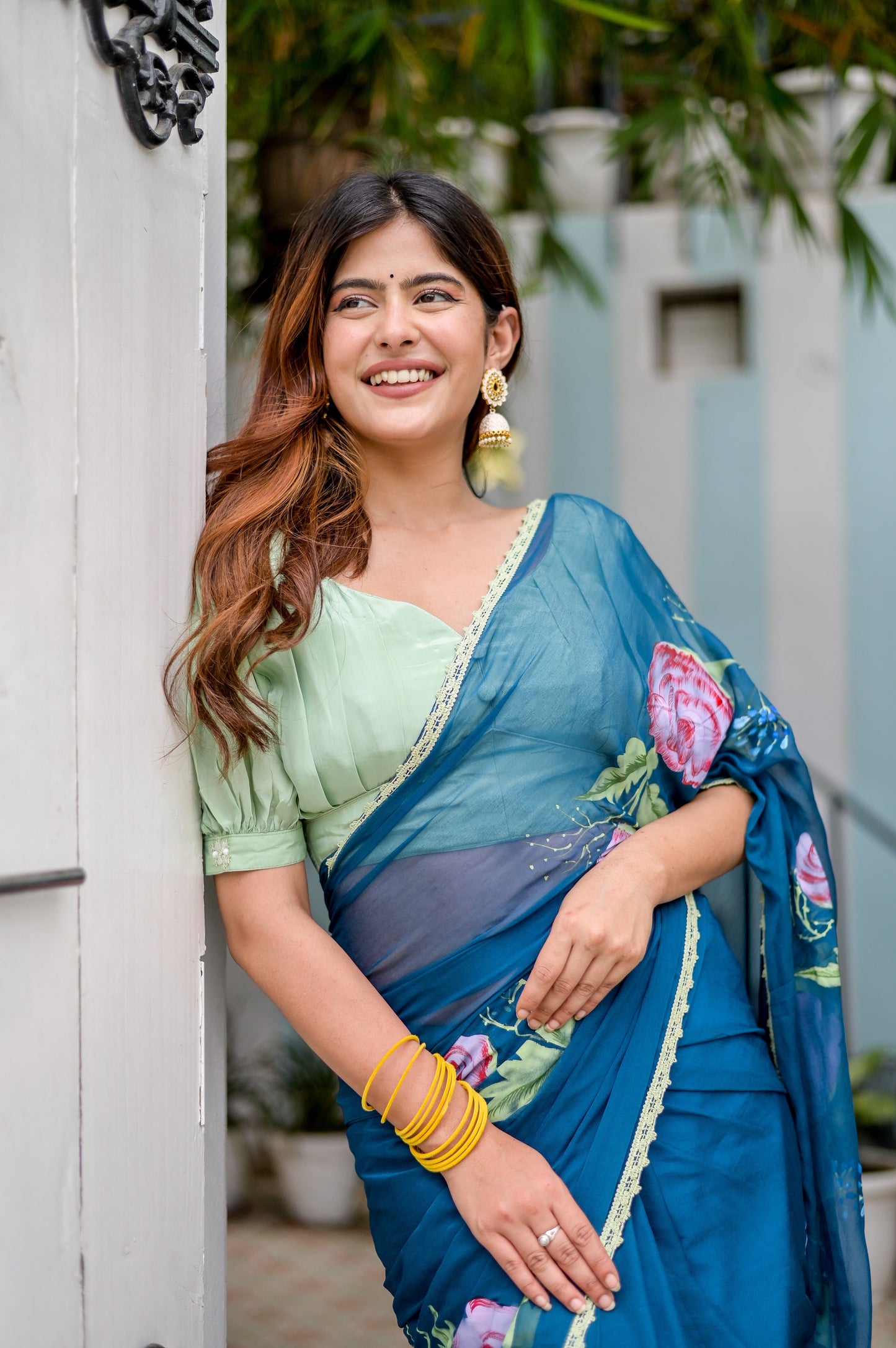 Elegant woman wearing a unique blue saree for special occasions, paired with green blouse and accessories