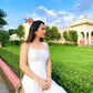 Woman wearing a white dress with floral designs, showcasing unique casual dresses for women in a garden setting