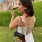 A woman wearing a white dress with a lace-up back, showcasing unique casual dresses for women