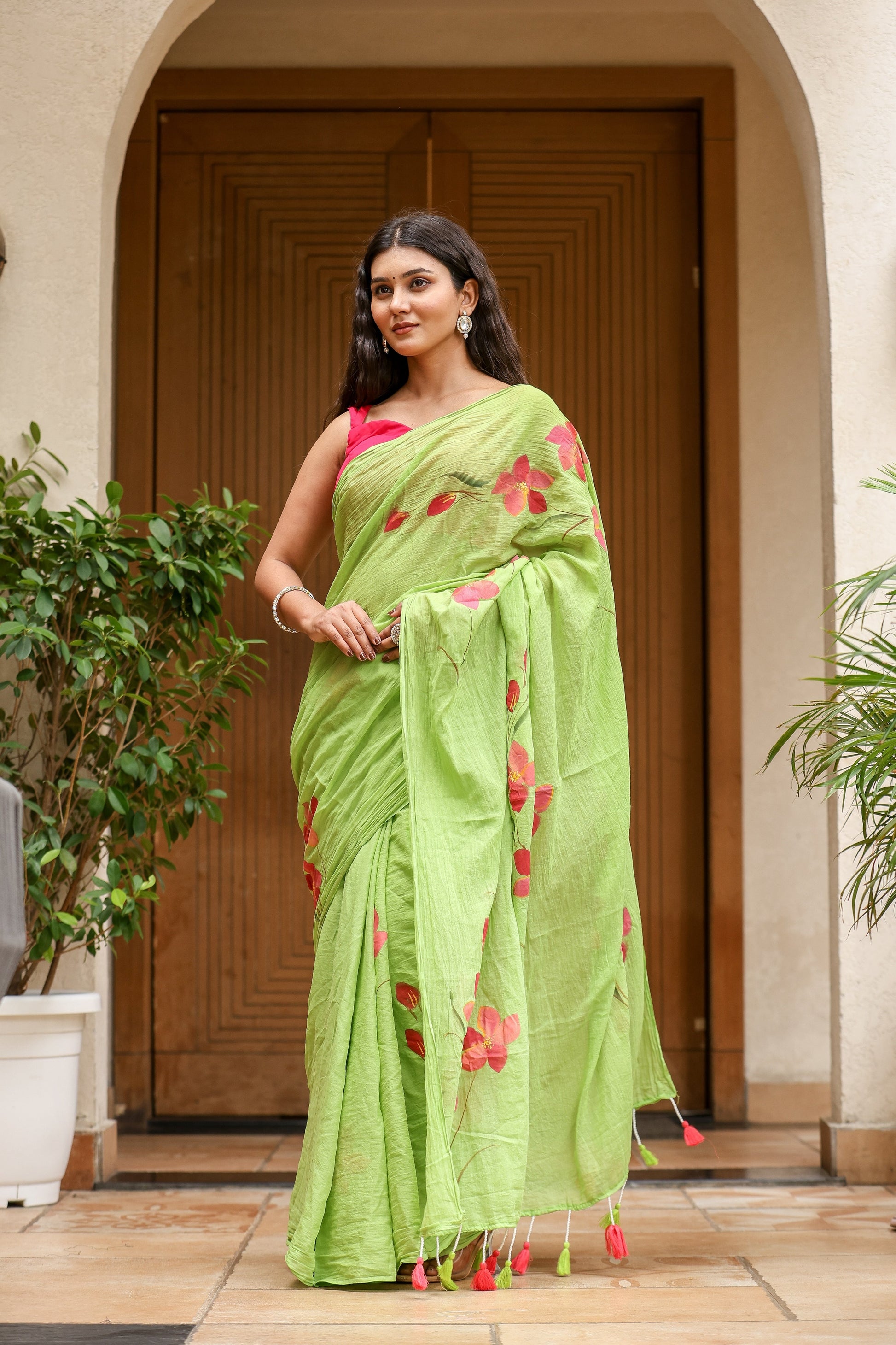 Unique designer malmal saree in green with floral patterns and tassels, perfect for elegant occasions