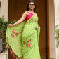 Model draped in a unique designer malmal saree in green with floral embroidery and tassels