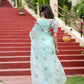 Elegant woman in a unique designer organza saree with floral embroidery walking down steps