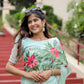 Graceful woman wearing a unique designer organza saree with vibrant floral embroidery outdoors