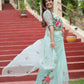 Model showcasing a unique designer organza saree in mint green with floral embroidery and matching blouse
