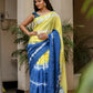 Model wearing a unique designer saree for women in blue and yellow with intricate tie-dye patterns