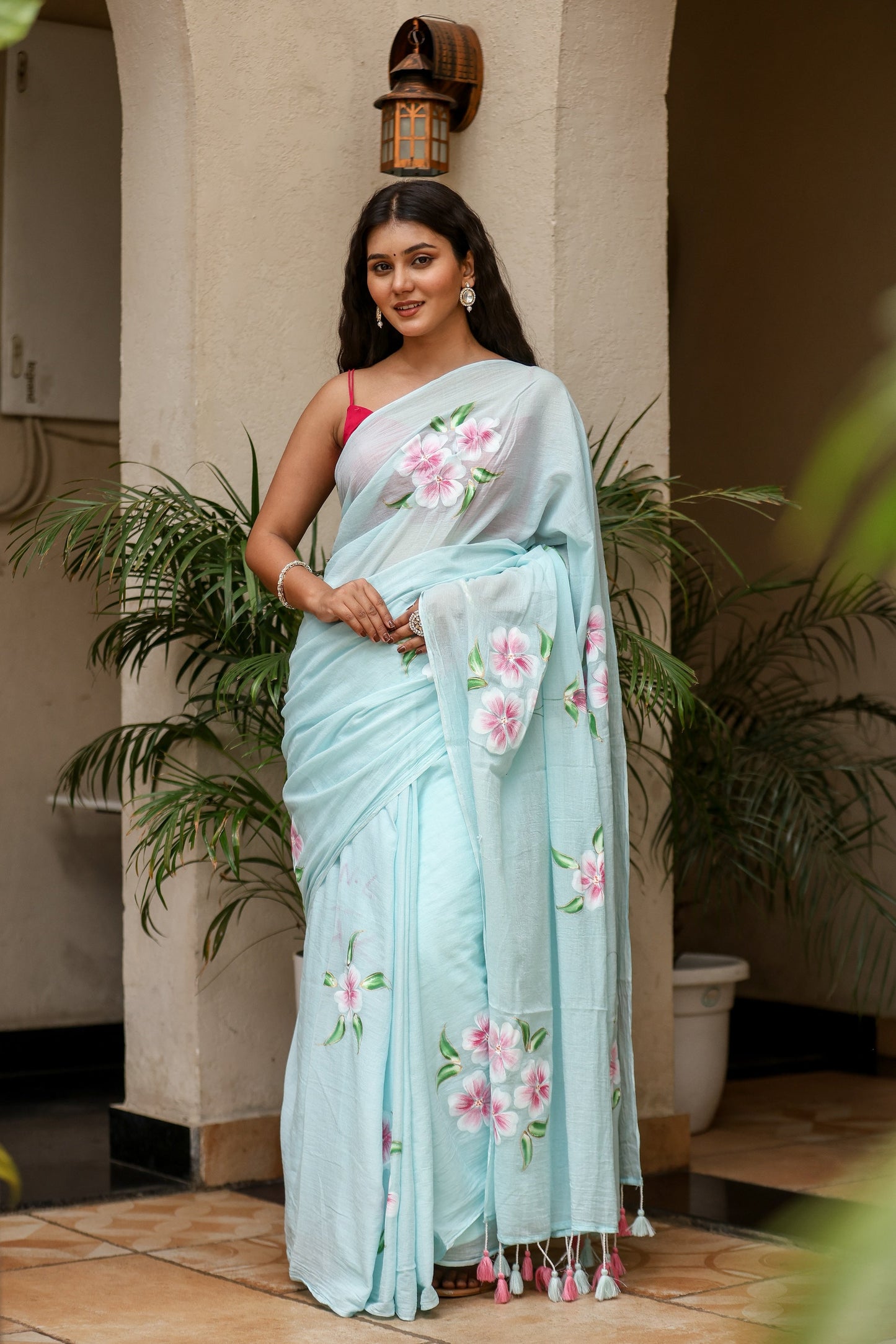 Elegant light blue unique designer sarees for parties featuring floral embroidery and tassel details.