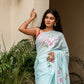 Elegant woman wearing a light blue saree with floral designs, showcasing unique designer sarees for parties