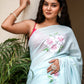 Elegant woman draped in a light blue saree with floral designs, showcasing unique designer sarees for parties