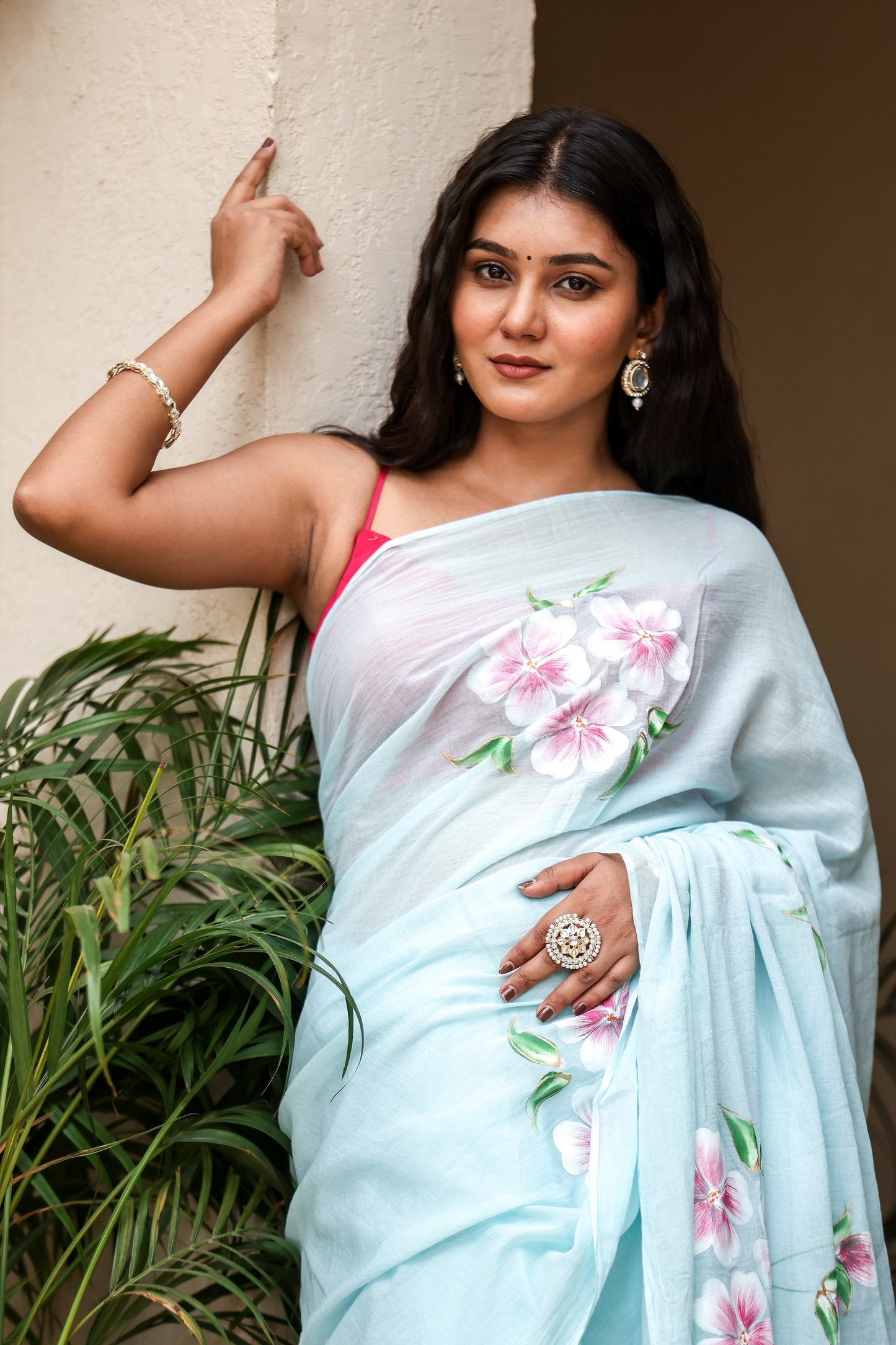 Elegant woman draped in a light blue saree with floral designs, showcasing unique designer sarees for parties