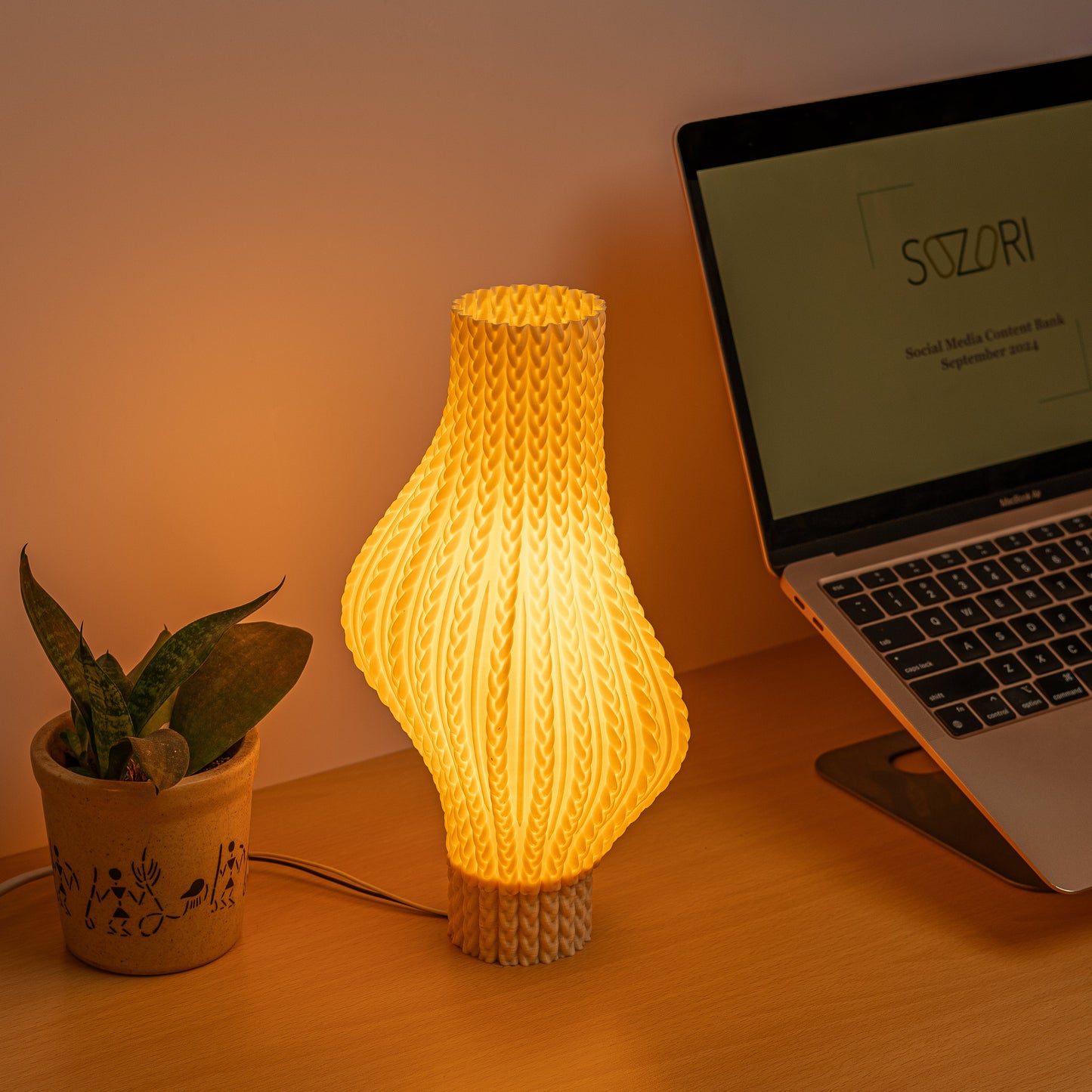 Sozori unique desk lamp for home office with warm yellow glow and stylish design next to a plant