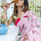 Elegant model wearing a unique handpainted saree for weddings with floral designs and pink hues