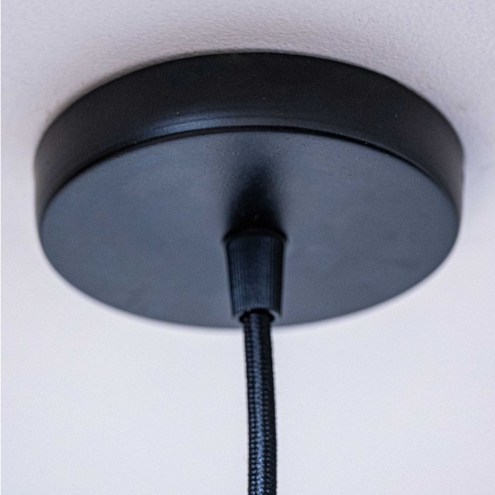 Black ceiling mount for unique home decor lamps with a sleek design and durable cord