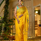 A woman wearing a unique Indian saree with embroidery in vibrant yellow, displayed elegantly at a festive setting