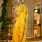 Elegant woman wearing a unique Indian saree with embroidery in vibrant yellow at a festive location
