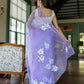 Model wearing a unique organza saree with artwork featuring floral designs in a serene indoor setting