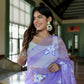 Model wearing a unique organza saree with artwork, featuring floral designs in lavender hues