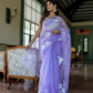 Model wearing a unique organza saree with artwork in lavender, showcasing floral designs and elegant draping.
