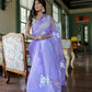 Model wearing a unique organza saree with artwork in lavender color, styled elegantly indoors
