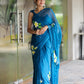 Elegant woman wearing a unique party wear saree in blue with floral embroidery, perfect for celebrations