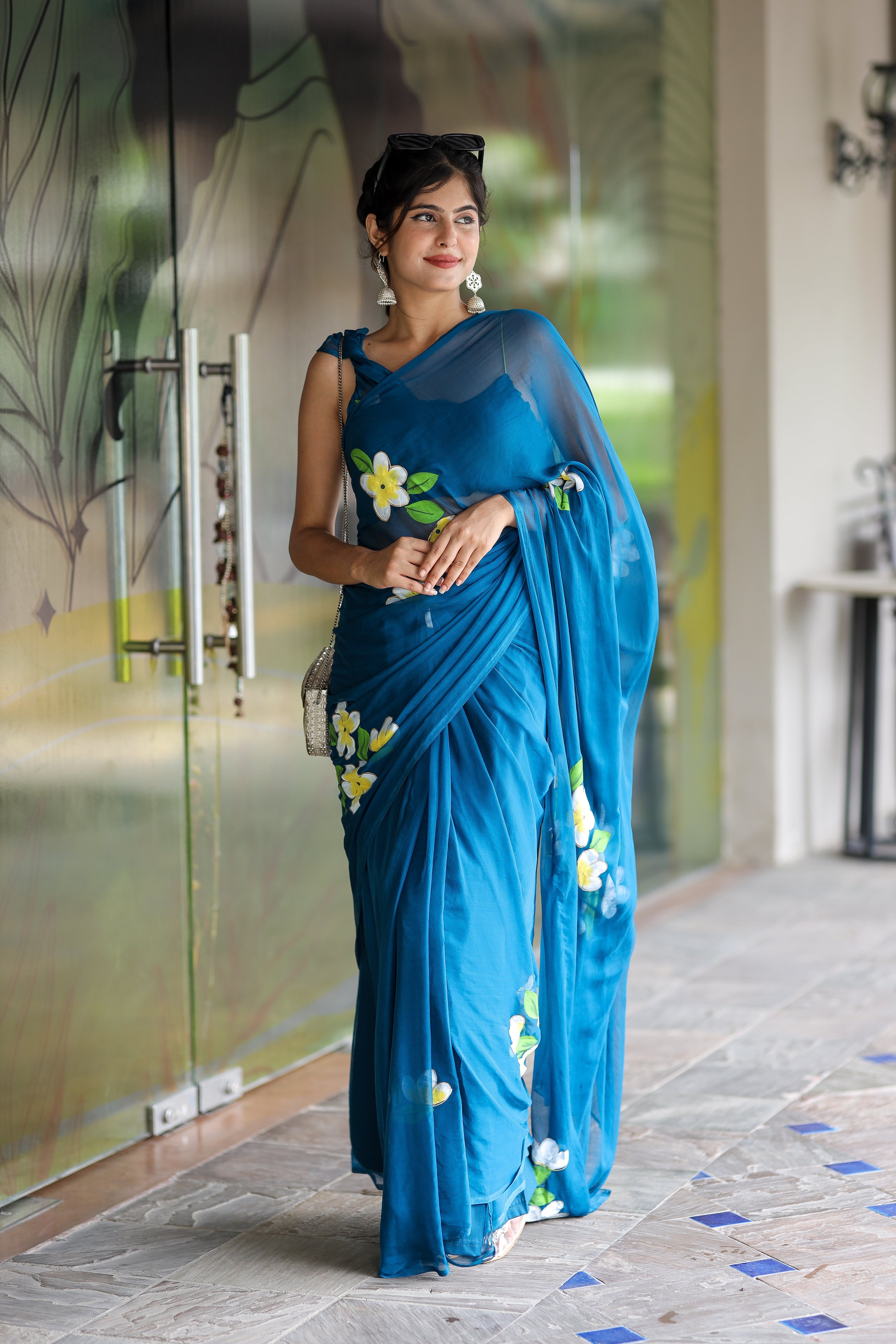 Elegant woman wearing a unique party wear saree in blue with floral embroidery, perfect for celebrations