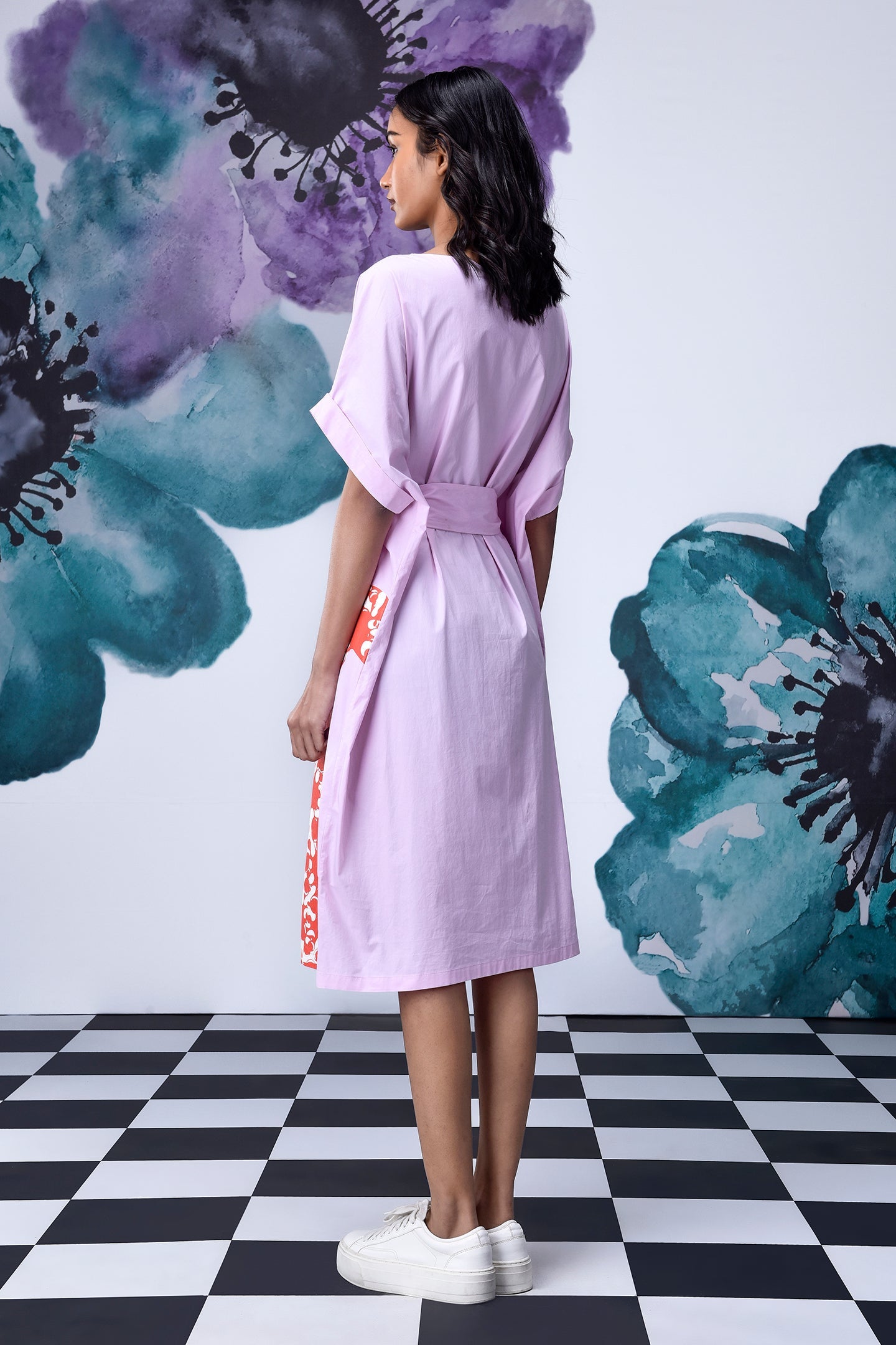 Stylera model back view lilac dress with belt and orange side panel white sneakers unique print relaxed fit dress