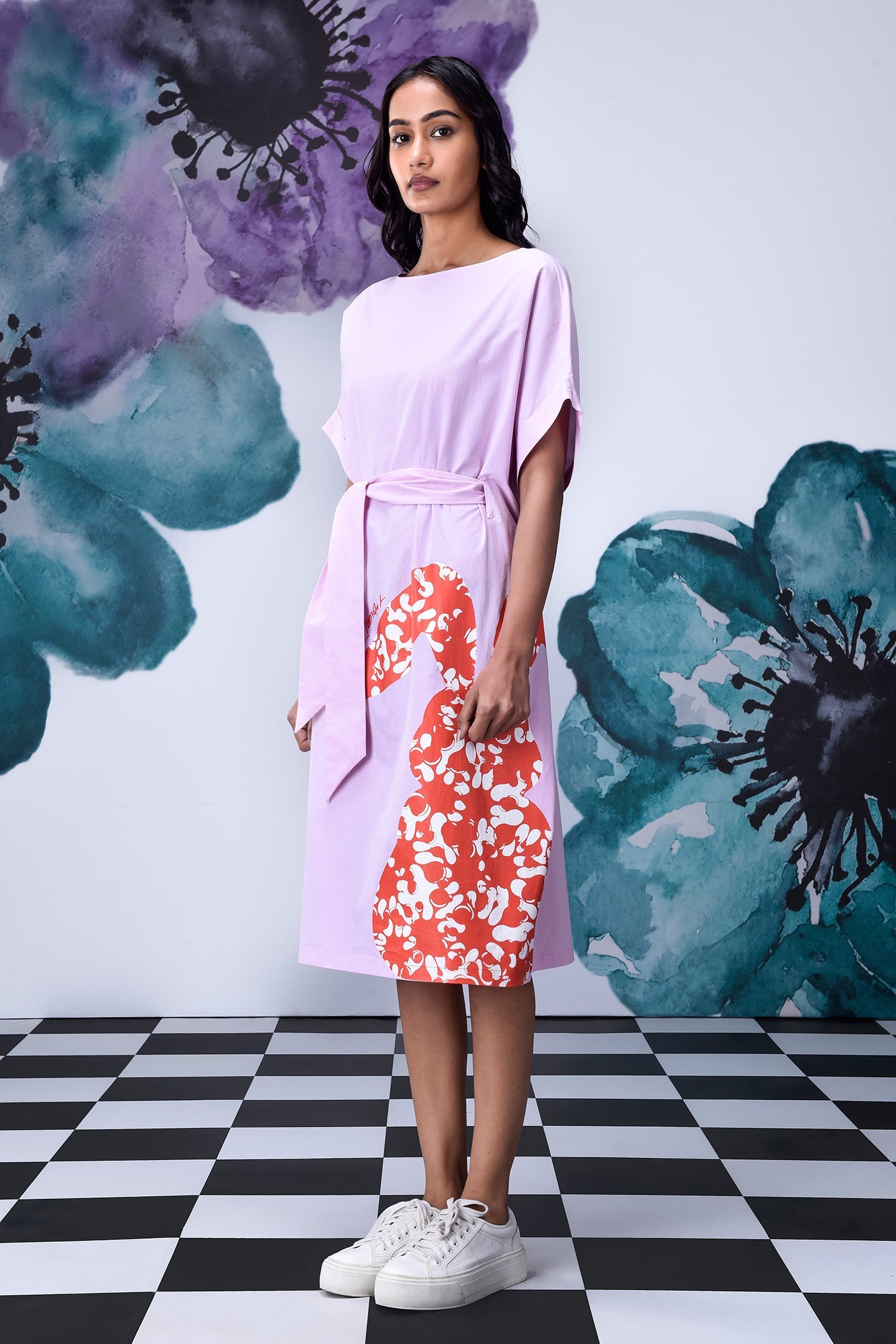 Model wearing Stylera unique print relaxed fit dress in lilac with orange floral panel and tie belt