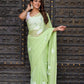 Elegant light green saree by Stylera with floral patterns, perfect as a unique saree for wedding guest.