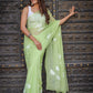 Stylera unique saree for wedding guest in soft green with floral patterns draped elegantly
