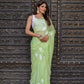 Elegant light green unique saree for wedding guest with floral motifs and graceful draping