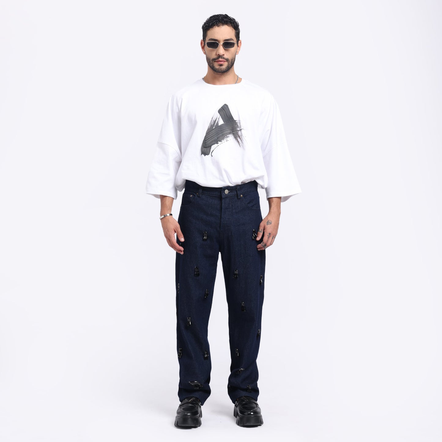 Stylera unique statement jeans for men displayed with a casual white graphic shirt and stylish sunglasses
