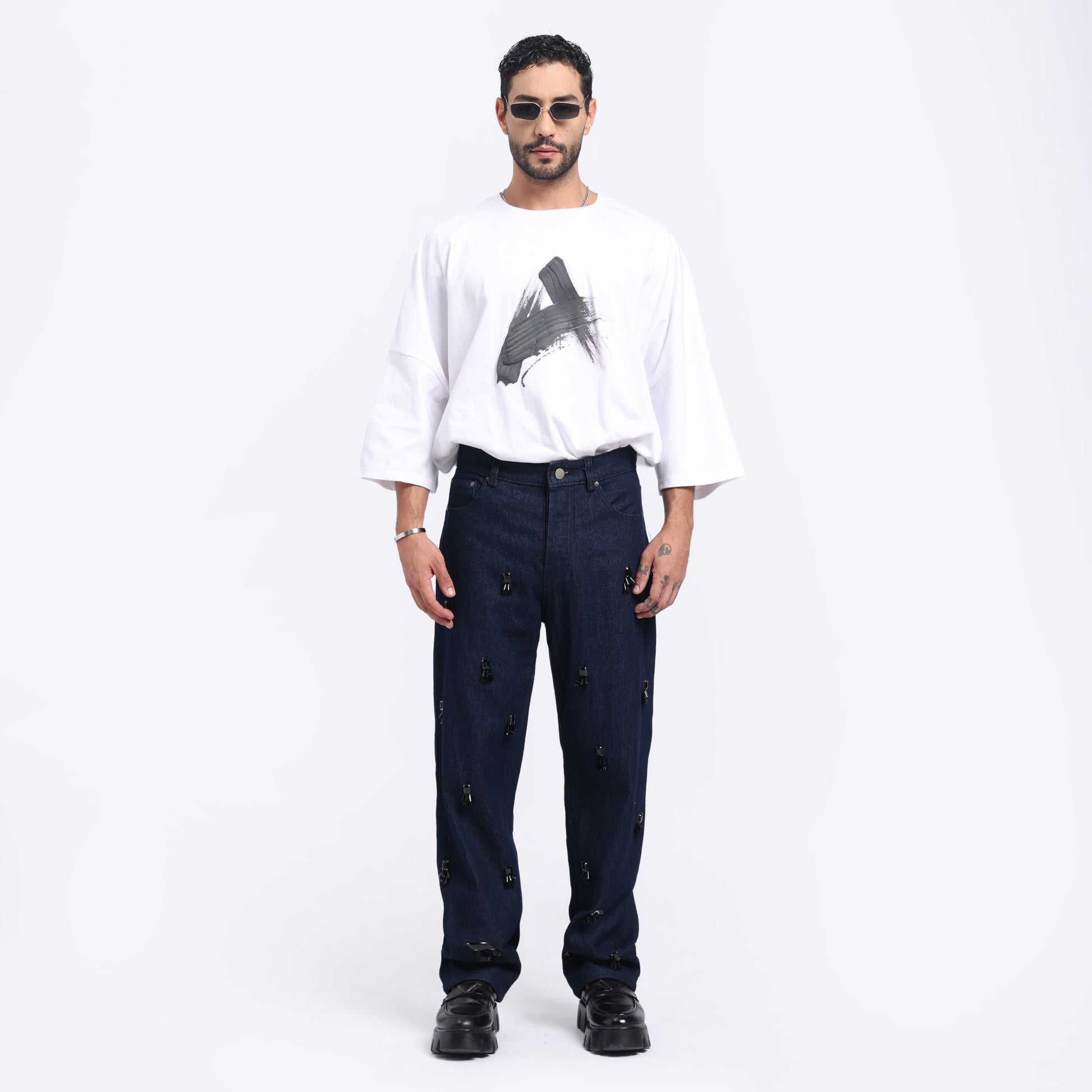 Stylera unique statement jeans for men displayed with a casual white graphic shirt and stylish sunglasses