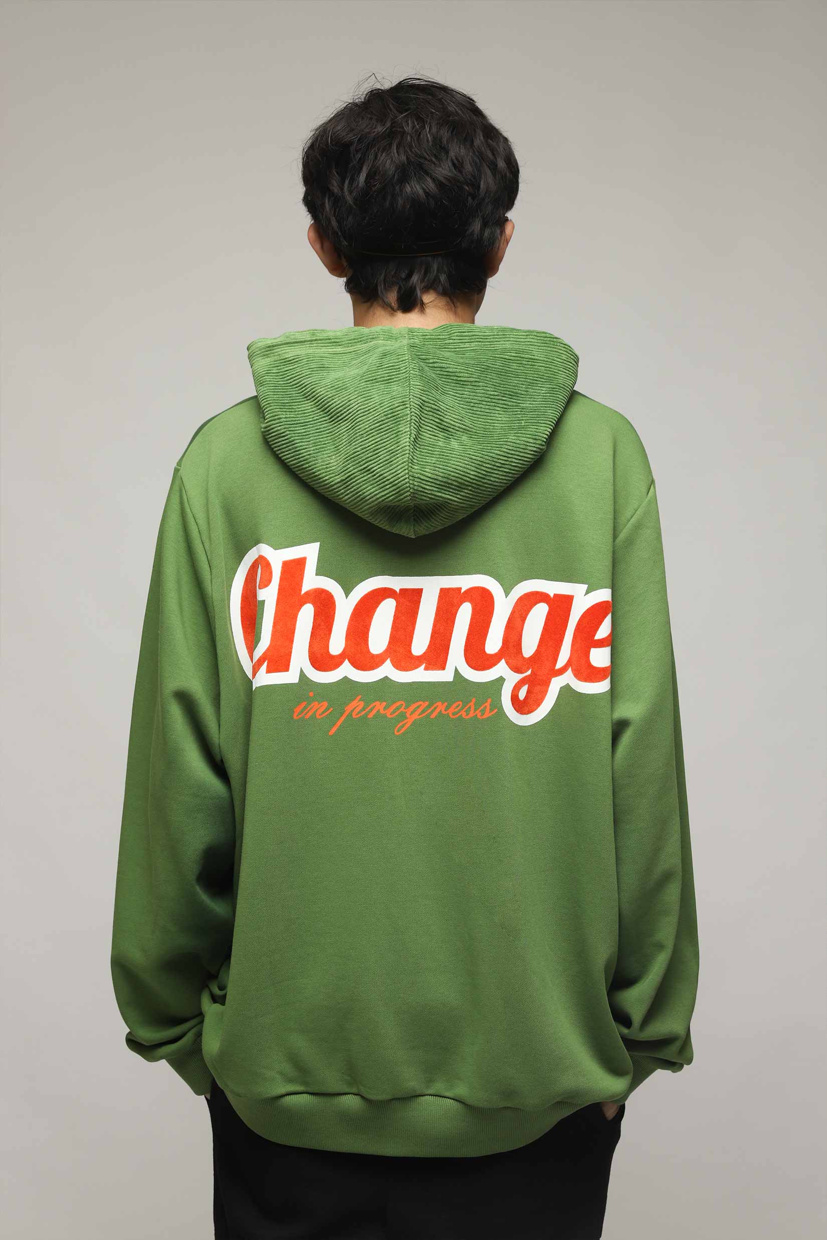 Stylera green hoodie back view with Change in progress bold orange and white graphic text unique streetwear hoodie