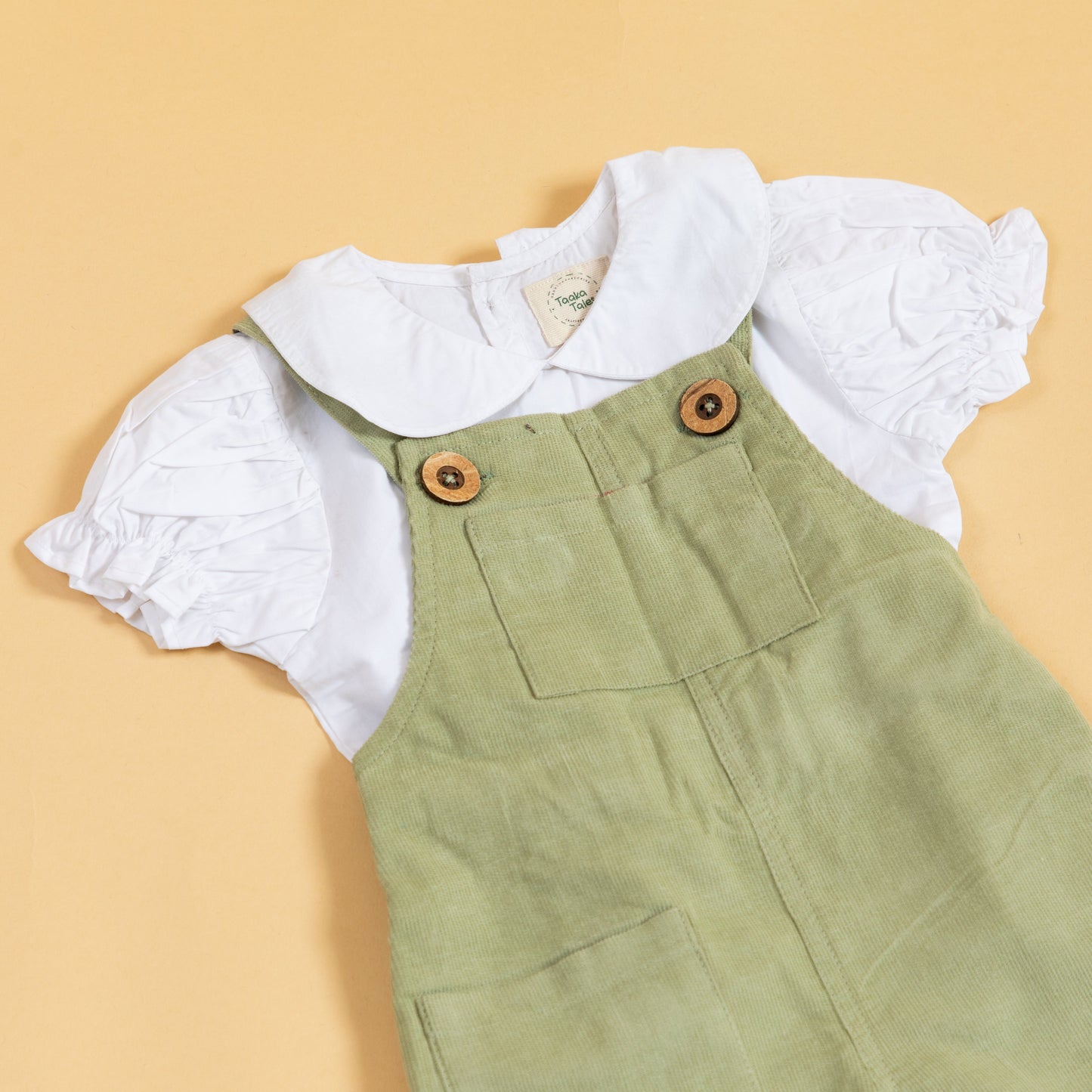 Unisex green dungarees for kids made of soft fabric with buttons and pockets